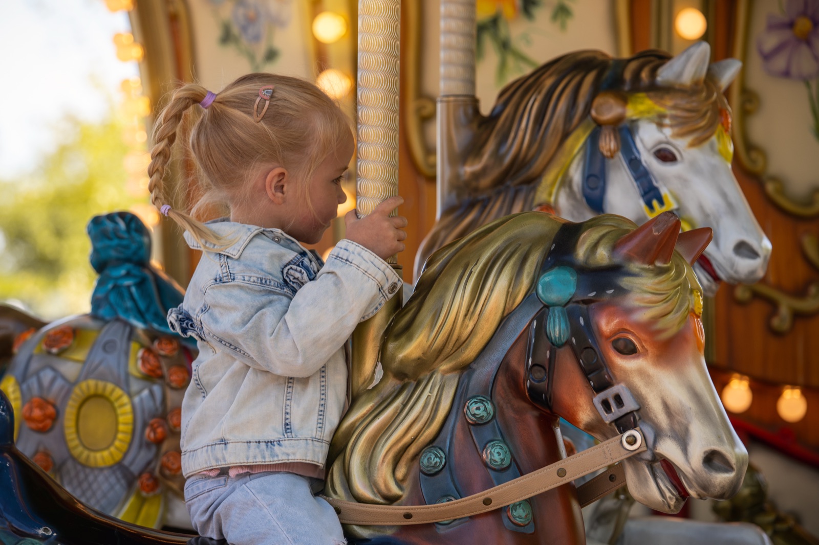 Kleines Mädchen auf einem Karussellpferd im Taunus Wunderland